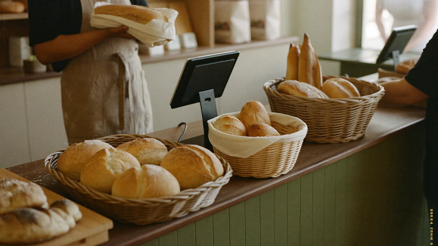 Mostrador de panadería con canastos de pan y la tablet de cobro entre ellos
