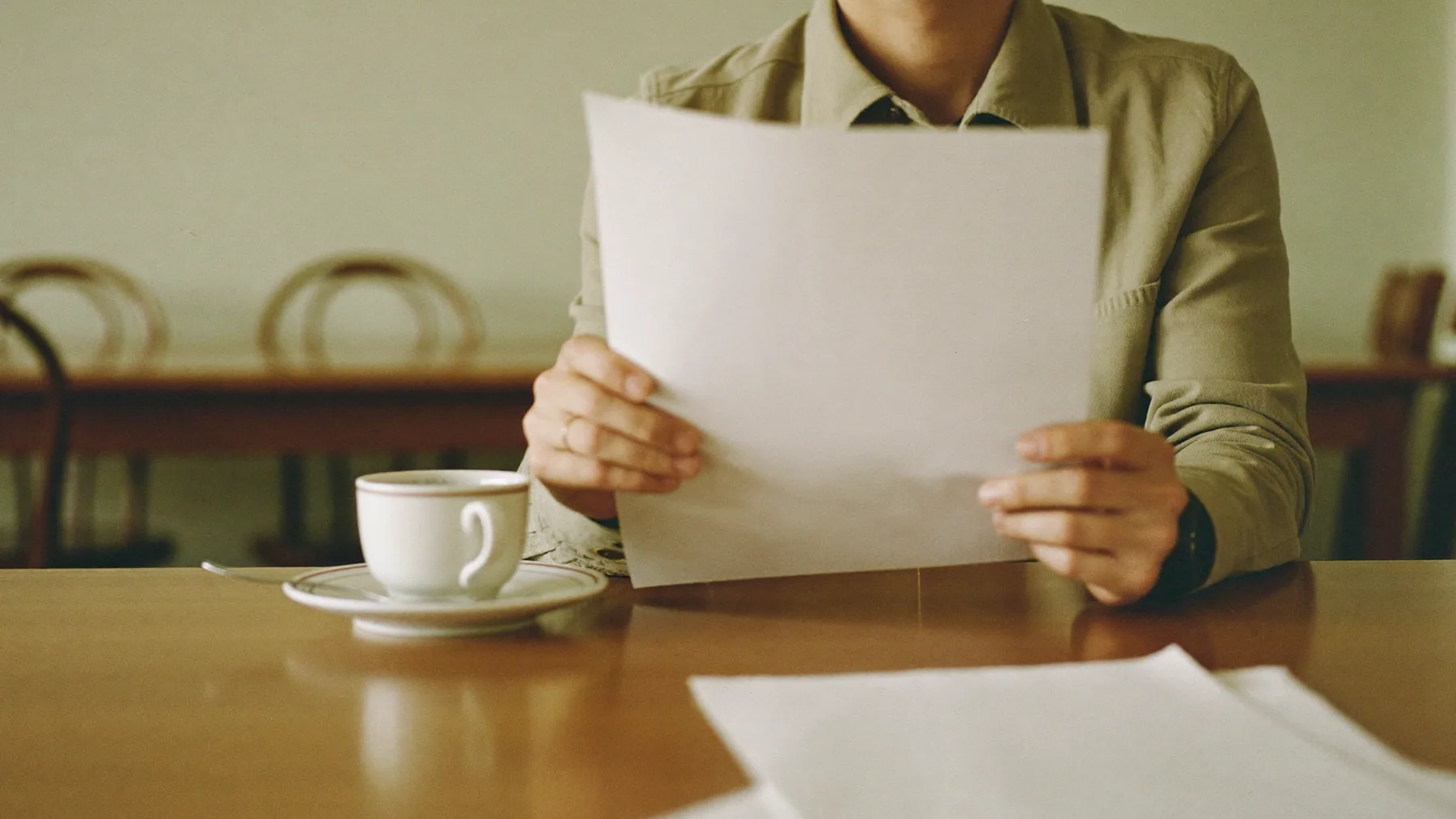 Dueño revisando una carpeta de facturas pendientes en una mesa del local