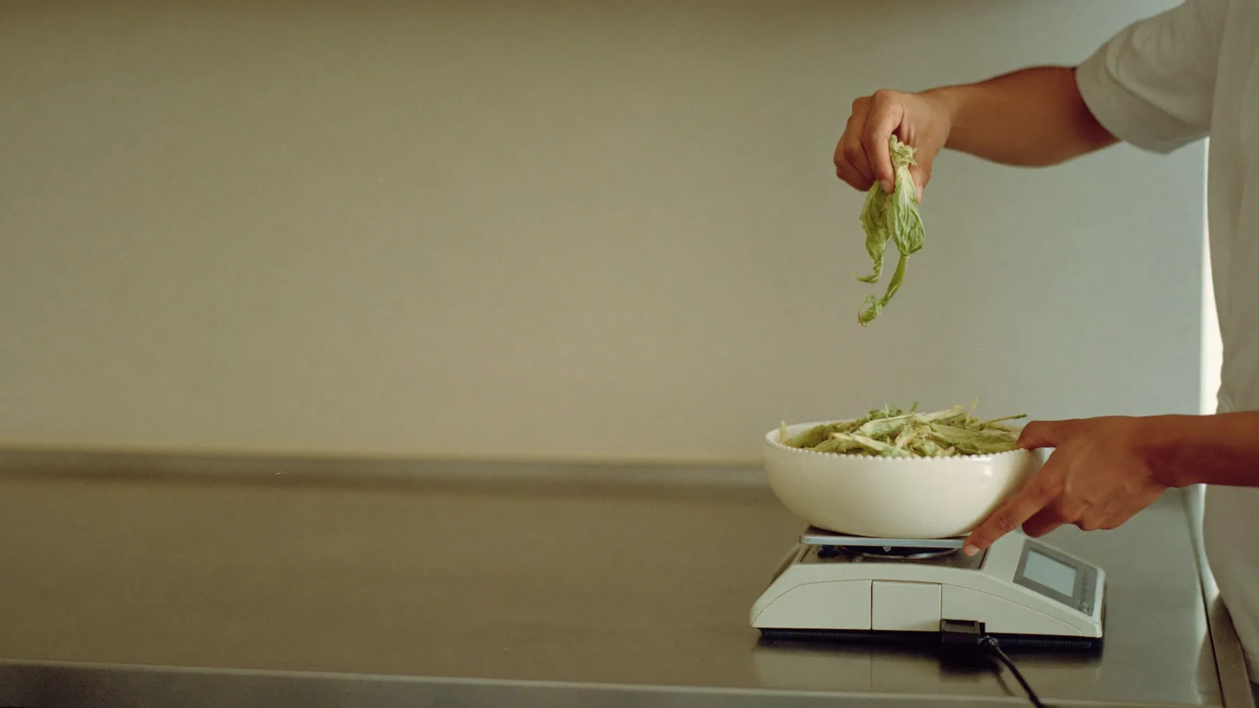 Cocinero pesando la merma de verduras antes de descartarla