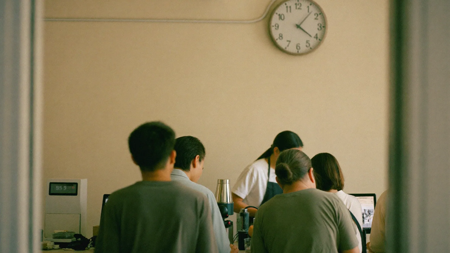 Fila en el mostrador de la cafetería a las 8 de la mañana bajo el reloj de pared