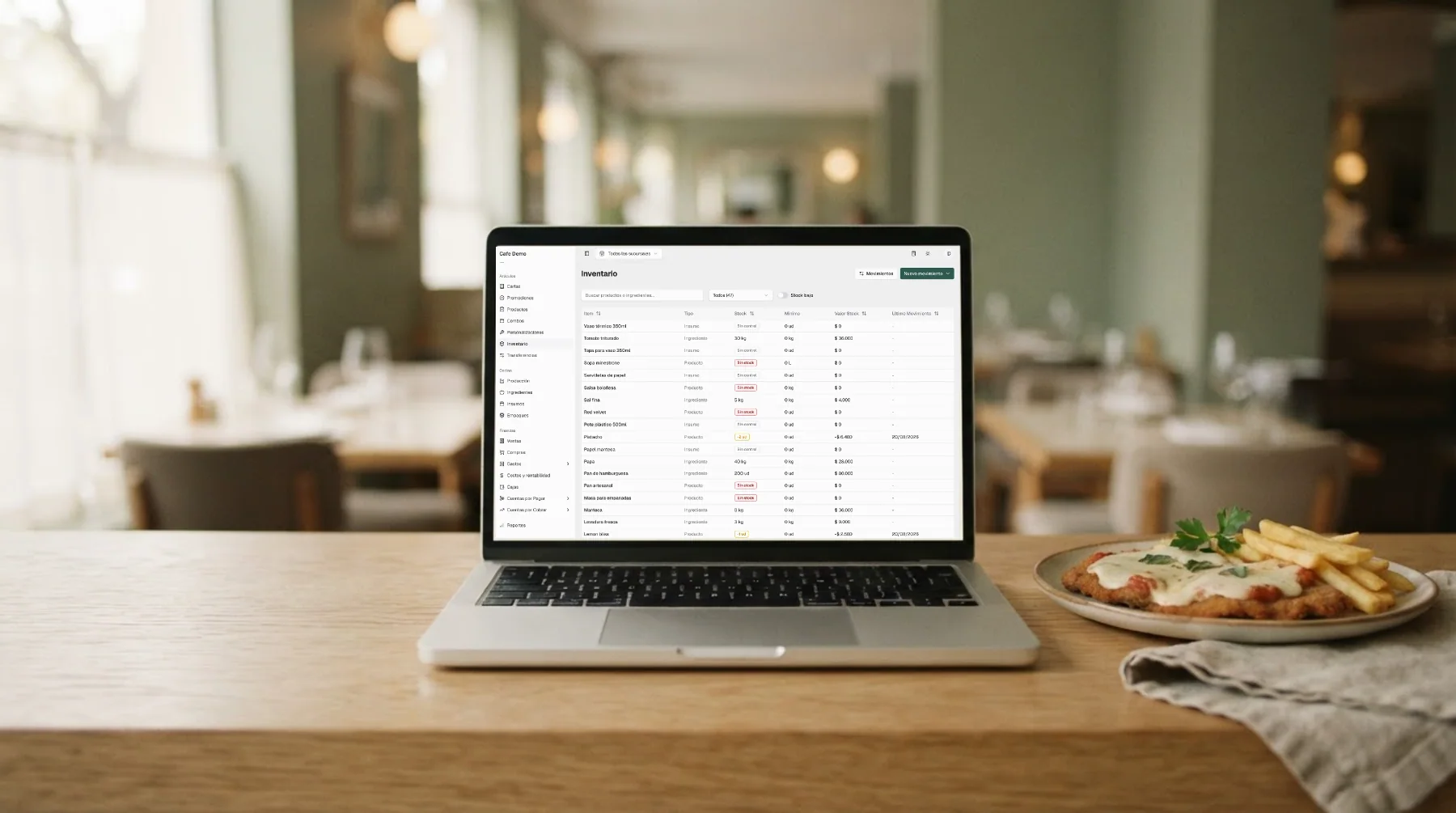 Laptop en el mostrador de un restaurante con el inventario de Mellysoft en pantalla, junto a una milanesa napolitana recién servida