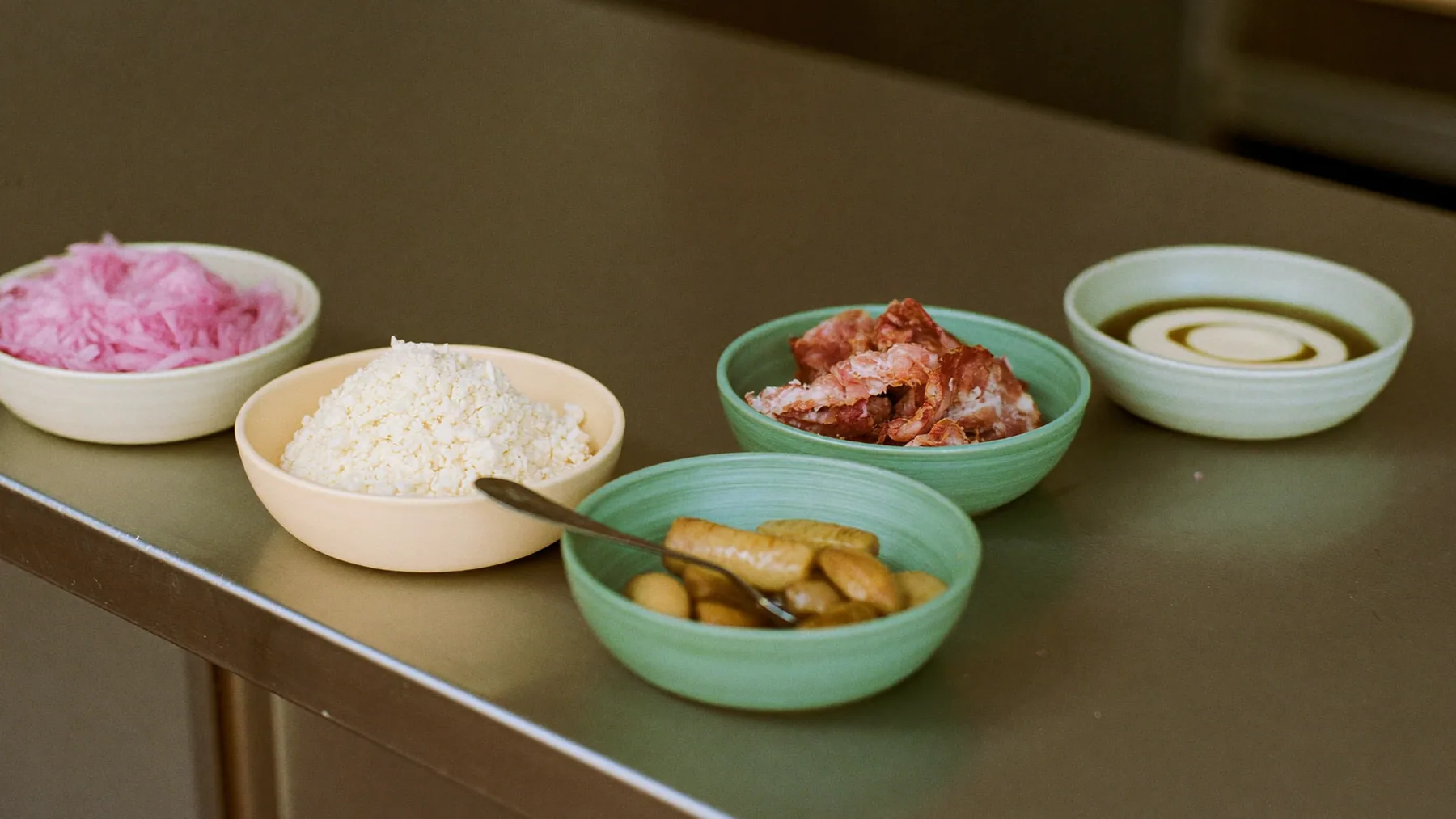 Barra de extras con cuencos de queso, cebolla y panceta para personalizar